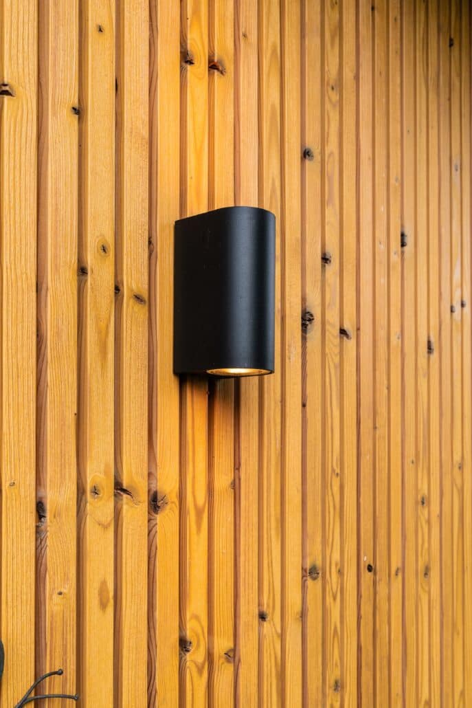 Moderne mantelzorgwoning van Solilux in Loenen met verticale gevelbekleding in warme houttinten, plat dak en overdekt terras, gelegen in een ruime, groene tuin.
