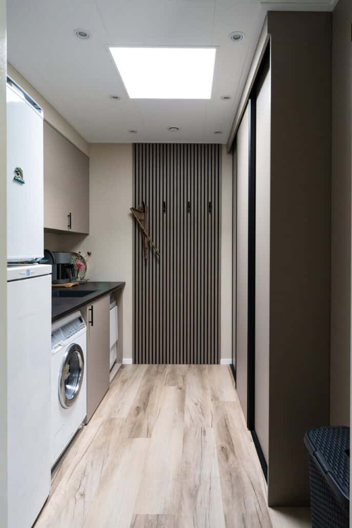 Moderne mantelzorgwoning van Solilux in Loenen met verticale gevelbekleding in warme houttinten, plat dak en overdekt terras, gelegen in een ruime, groene tuin.